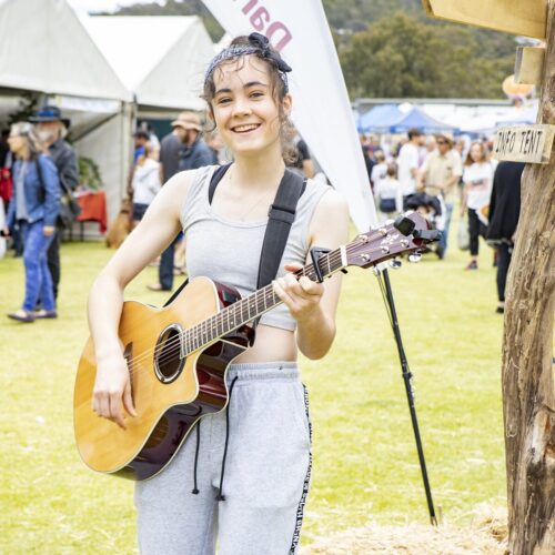 Woman playing a guitar entertaining at the Darlington Arts Festival