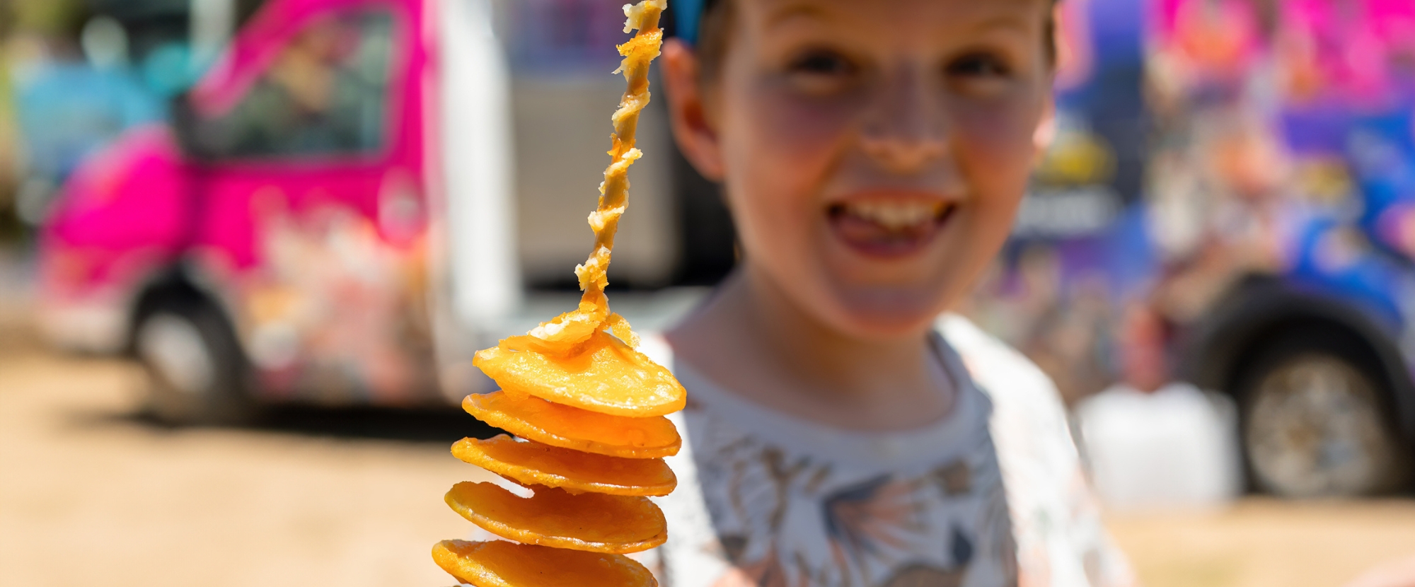 Boy eating a cooked spiral potato