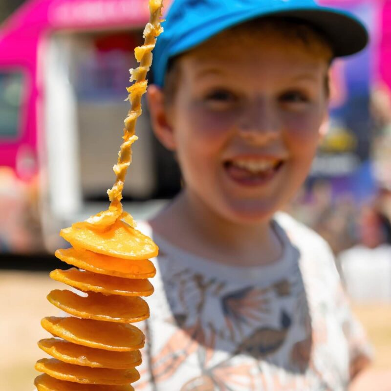 Boy eating a cooked spiral potato