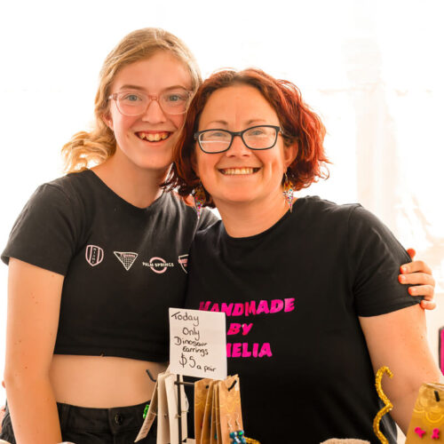 Stallholders hugging in their stall selling earrings